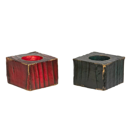 Two handcrafted wooden Christmas fence post tealight holders, 50mm high. One finished in red and the one in green. Both have flashes of gold gilding paste. Shown on a white background.