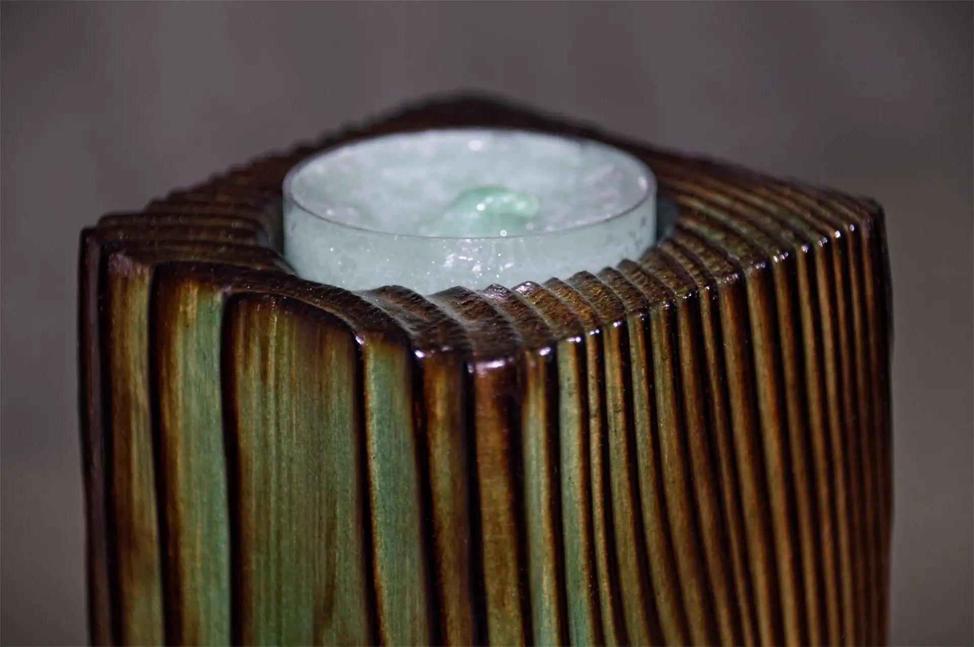 Close-up of a handcrafted fencepost tealight holder, in a Menthol colour.