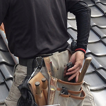 Image of the Zetsaw V Handy200 Daikume Folding Anahiki-nokogiri Japanese Saw being placed into the pouch of a toolbelt of a roofing worker.